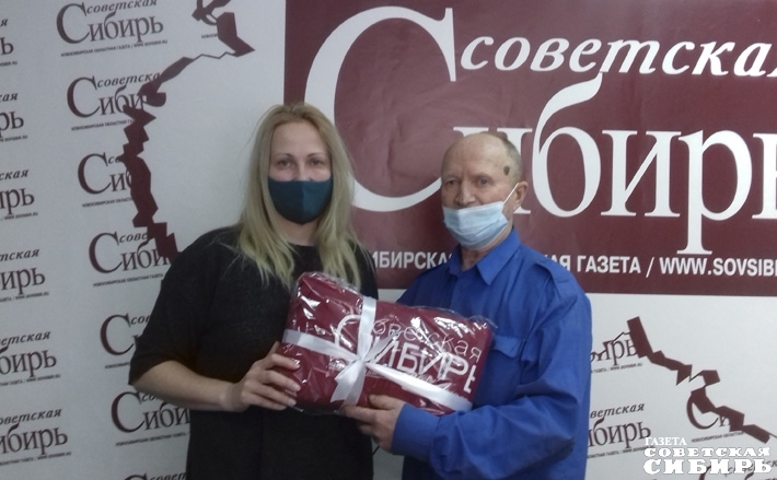 И. о. главного редактора «Советской Сибири» Юлия Назаренко вручила победителю конкурса «Я вам заметку принес!» Виталию Никитину залуженный приз — теплый плед с логотипом издательского дома. Фото: Людмила Селезнева