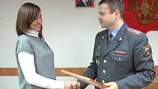 Валерий Ветров вручает Ксении Артемьевой награду за помощь в задержании опасного преступника.