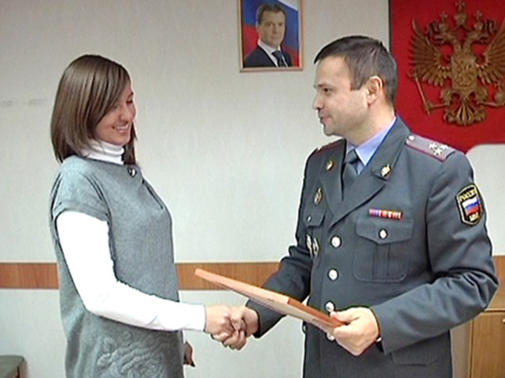 Валерий Ветров вручает Ксении Артемьевой награду за помощь в задержании опасного преступника.