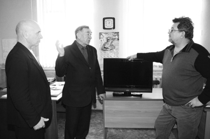 Василий Веретено вручает подарок клубу инвалидов.