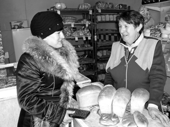 В магазине «Горячий хлеб» продавец Валентина Табакова отпускает товар покупателю.