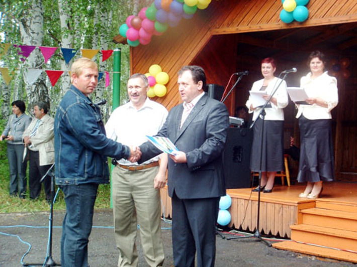 Глава Кочковского района Петр Шилин (справа) и председатель районного Совета депутатов Юрий Горлатых вручают награду бригадиру животноводства ЗАО «Решетовское» Дмитрию Бухтину.