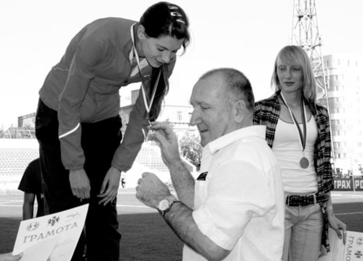 Ирину Жирнову награждает заместитель руководителя департамента физической культуры и спорта Новосибирской области Александр Веселов. Рядом — бронзовый призер соревнований в беге на 800 метров, воспитанница ШВСМ Елена Кобелева.