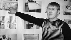 Сергей Седлецкий демонстрирует ассортимент своих товаров, запечатленный на специальном стенде.