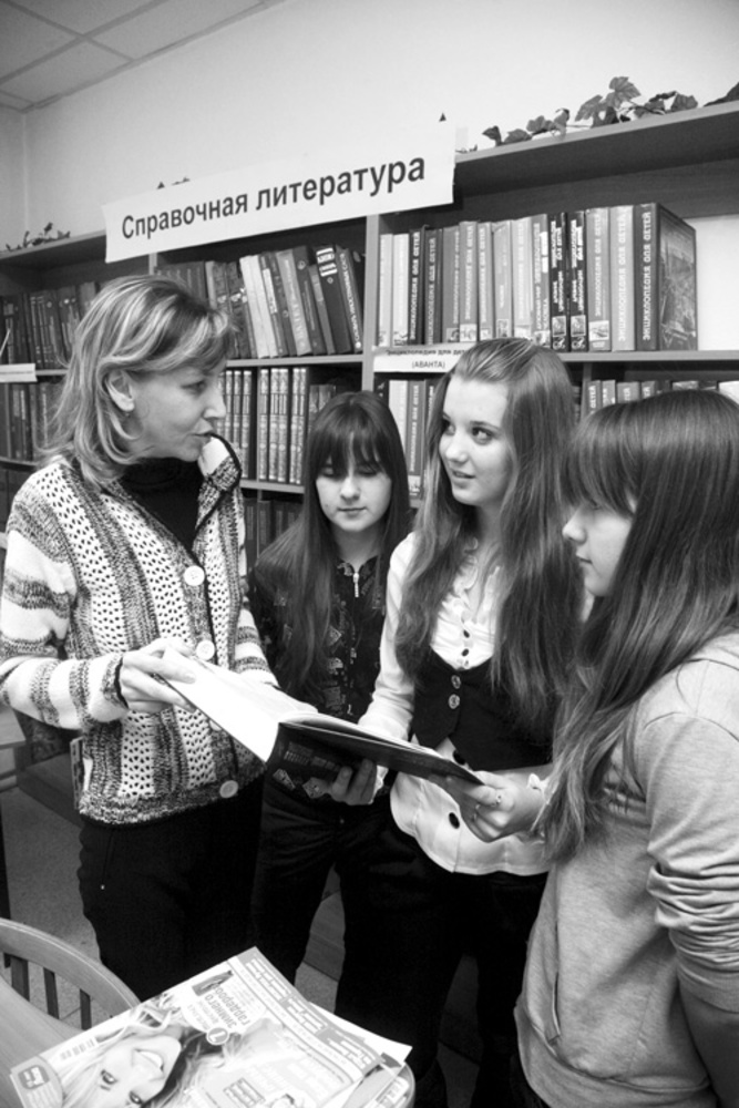 Заведующая библиотекой Ольга Марникова с юными читателями.