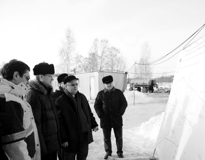 Участники рабочей поездки изучают карту строительства.