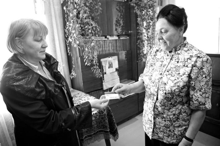 Галина Рыкова вручает дисконтную социальную карту Анне Мишустиной. Теперь можно спокойно ехать на дачу. Фото Михаила ПЕРМИНА