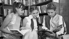 Поздравить любимую библиотеку пришли школьники.  В перерывах между выступлениями они нашли минутку, чтобы почитать. Фото Михаила ПЕРМИНА