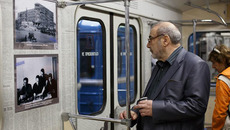 Владимир Калужский рассматривает фотографии, размещенные на стенах вагона. Фото Геннадия ДАНИЛКИНА