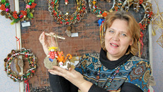 Галина Волченко с оберегом «Мир вашему дому» на фоне рождественских венков. Фото Николая ЦАРЕВА
