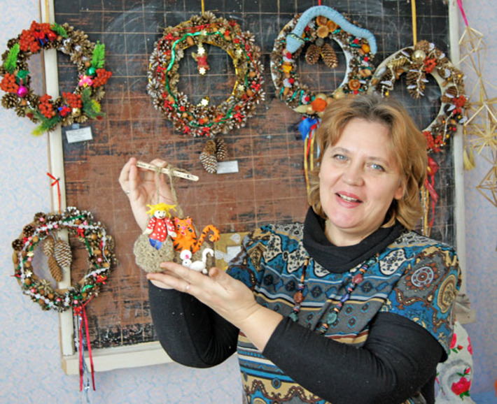 Галина Волченко с оберегом «Мир вашему дому» на фоне рождественских венков. Фото Николая ЦАРЕВА