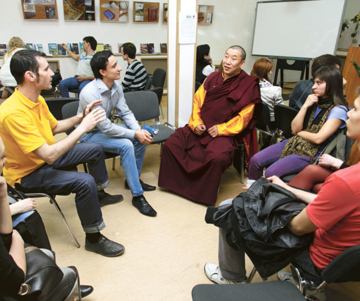 Посетители «читают» буддийского ламу. Фото Аркадия УВАРОВА