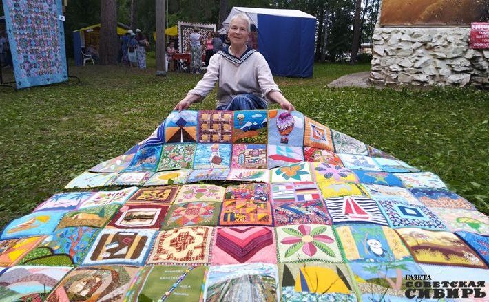 Елена Юдина демонстрирует фестивальное одеяло 2019 года — «Путешествие». Фото Юлии НАЗАРЕНКО