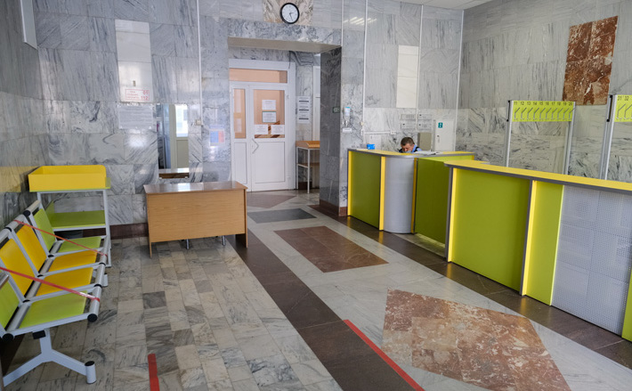 Когда заходишь сюда, не сразу понимаешь, что это обычная муниципальная амбулатория. Внутреннее убранство 90-летнего здания делает его больше похожим на театр или музей: высокие потолки с лепниной, парадная с регистратурой, мраморные полы, широкие лестницы, где даже петельки для крепления дорожек с прошлого века остались, замысловатые перила, на втором этаже — скульптура мальчика с мячом. Непросто содержать все это великолепие в образцовом порядке. И еще сделать его удобным для пациентов, наполнить современным оборудованием. Фото с сайта nso.ru