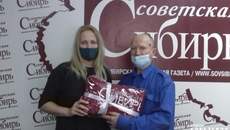 И. о. главного редактора «Советской Сибири» Юлия Назаренко вручила победителю конкурса «Я вам заметку принес!» Виталию Никитину залуженный приз — теплый плед с логотипом издательского дома. Фото: Людмила Селезнева
