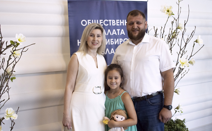 Для Алексея и Ирины Харитоновых приглашение на церемонию вручения медали «Достойная семья» стало неожиданным. На мероприятие их сопровождала дочь Оля. Фото: op.nso.ru