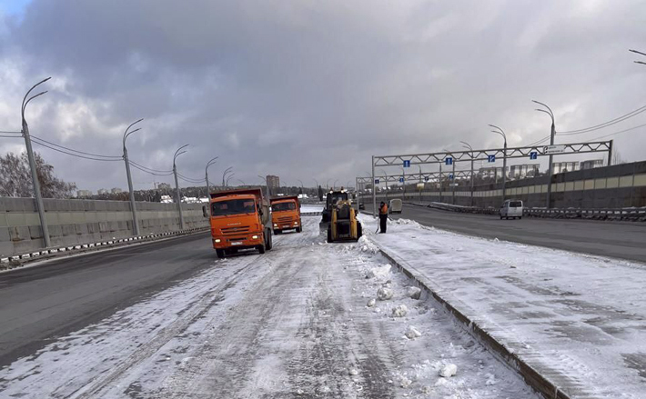 Коммунальные службы мегаполиса без выходных трудятся на очистке дорог, тротуаров и мостовых переходов. На фото слева работа уборочной техники на съезде Бугринского моста. Фото: пресс-служба мэрии Новосибирска